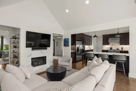 a kitchen with stainless steel appliances granite countertop a sink a stove and a wooden floors