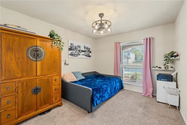 a bedroom with a bed and a chandelier
