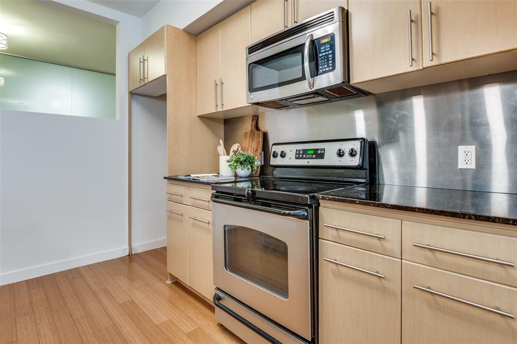 4040 North Hall Street, Unit 105 Dallas, TX 75219 - Photo 12 of 25 a kitchen with stainless steel appliances granite countertop a stove microwave and sink