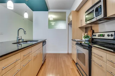 a kitchen with stainless steel appliances granite countertop a sink and a stove