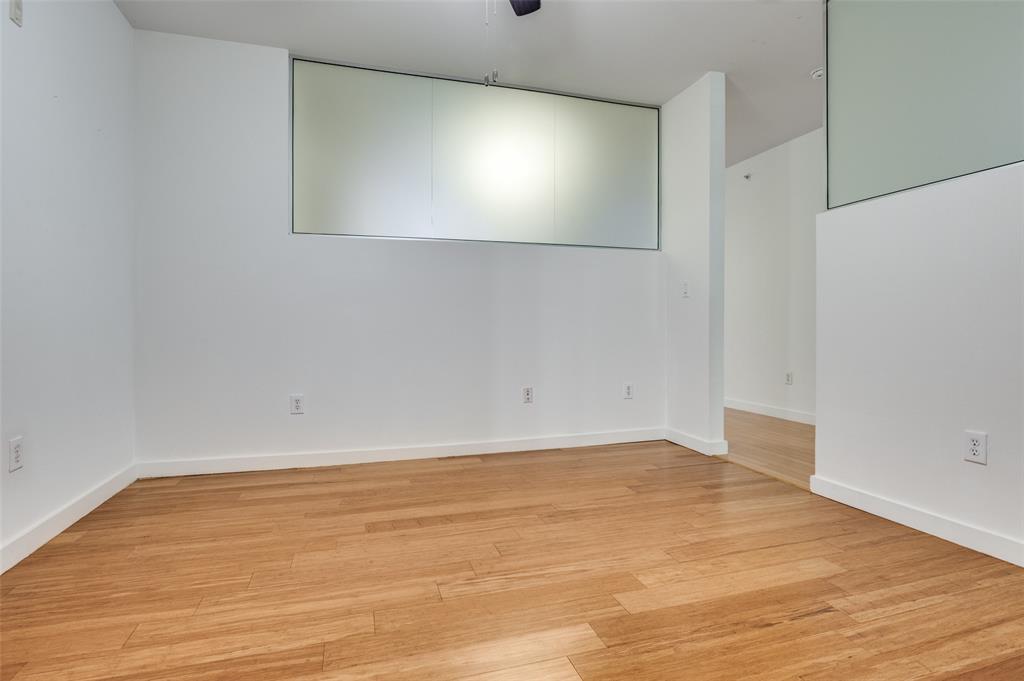 4040 North Hall Street, Unit 105 Dallas, TX 75219 - Photo 15 of 25 a view of an empty room with wooden floor and windows