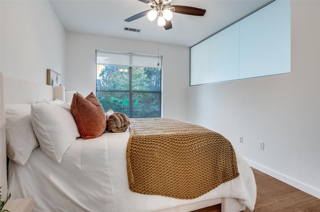 4040 North Hall Street, Unit 105 Dallas, TX 75219 - Photo 17 of 25 a bedroom with a bed and a chandelier