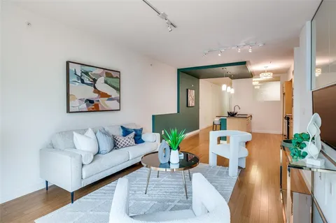 a living room with furniture and a large mirror with wooden floor