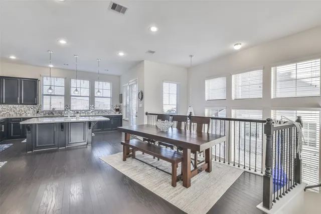 a living room with stainless steel appliances furniture and a kitchen view