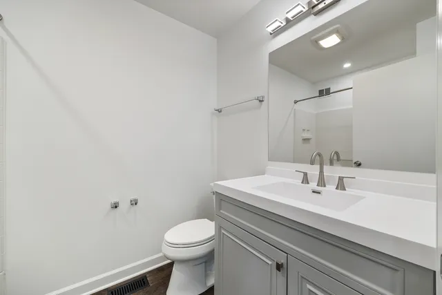 a bathroom with a sink a toilet and a mirror