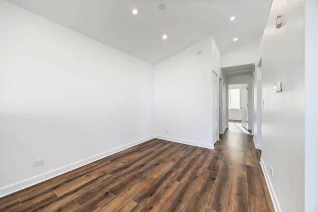 a view of a big room with wooden floor and windows