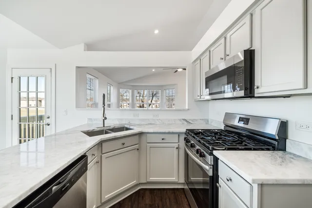 a kitchen with stainless steel appliances granite countertop a sink stove and cabinets