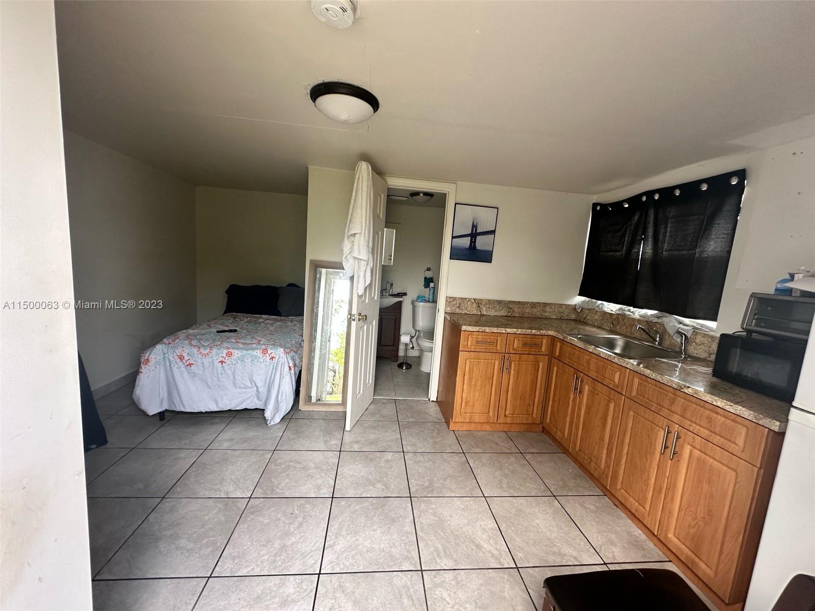 2131 Southwest 98th Place Miami, FL 33165 - Photo 18 of 22 a kitchen with a sink a stove and cabinets