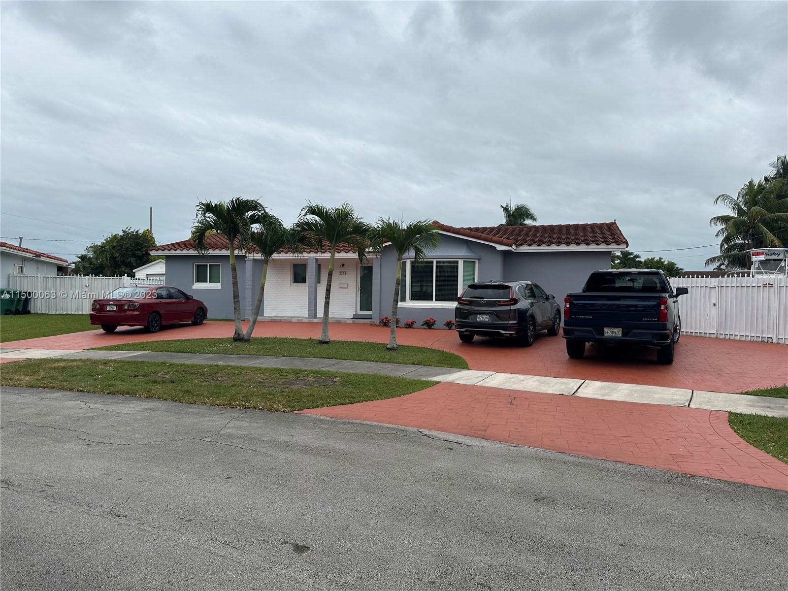 2131 Southwest 98th Place Miami, FL 33165 - Photo 2 of 22 a car parked in front of a house with a yard