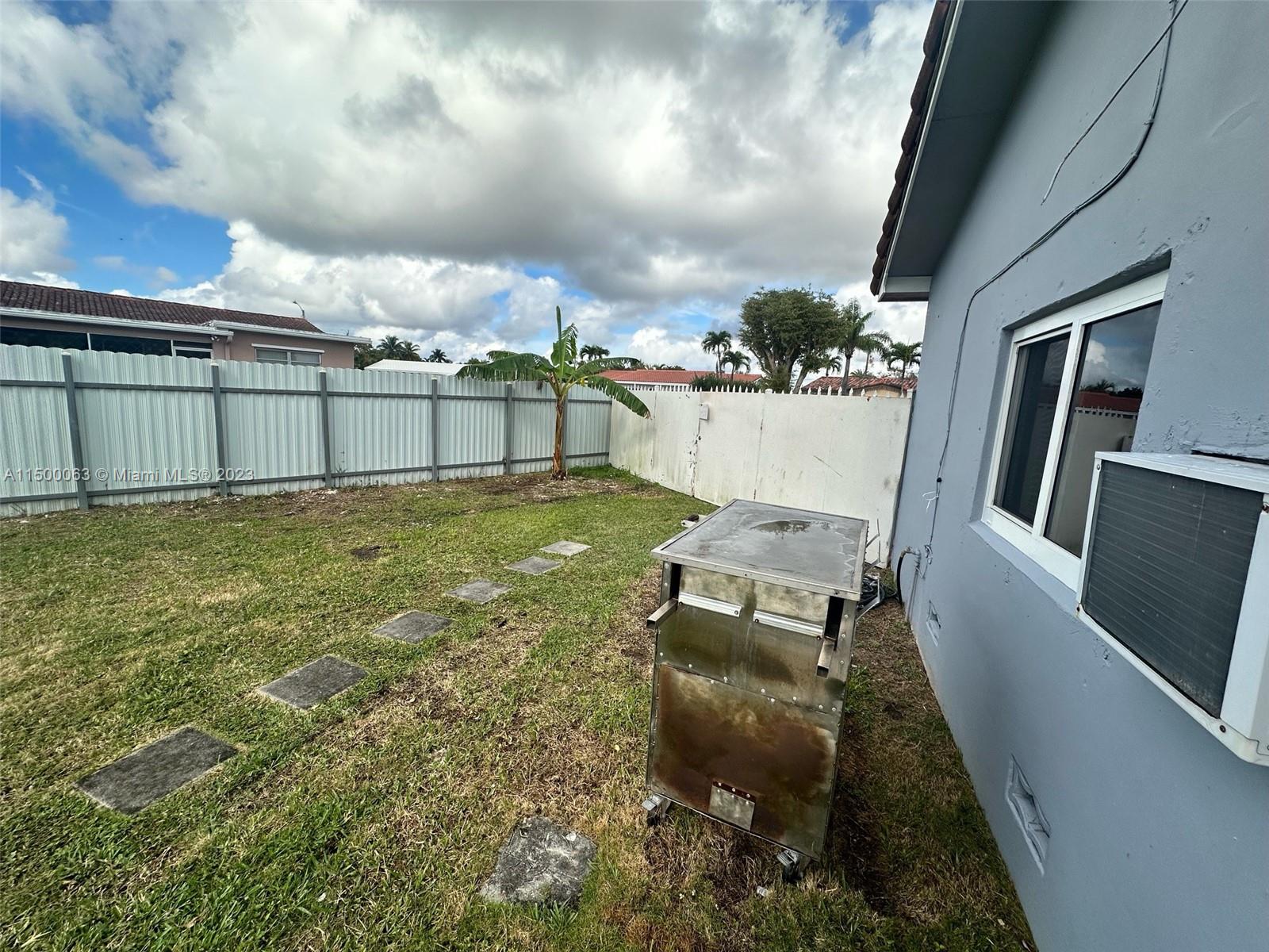 2131 Southwest 98th Place Miami, FL 33165 - Photo 21 of 22 a view of a chairs and table in backyard