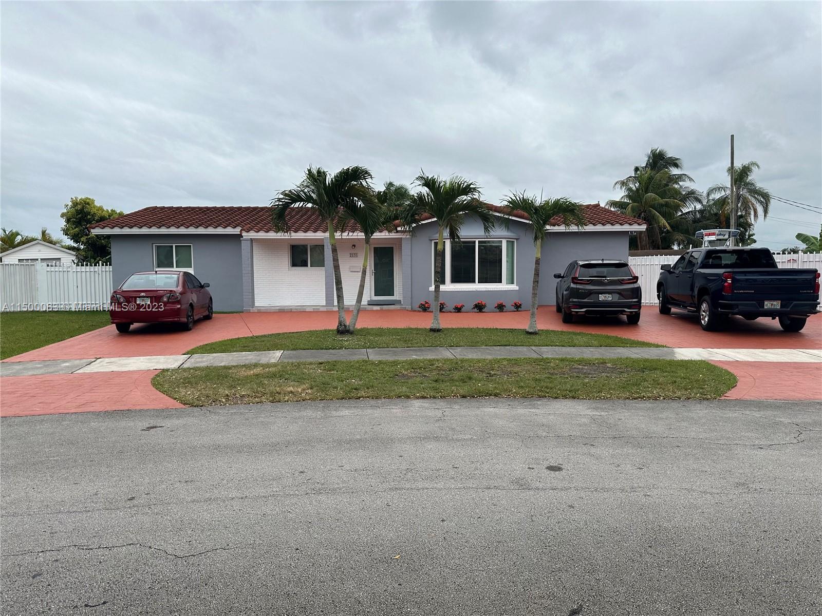 2131 Southwest 98th Place Miami, FL 33165 - Photo 3 of 22 a front view of a house with a yard and garage