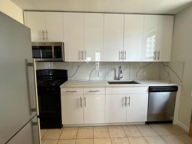 200 Corbin Place, Unit 2H Brooklyn, NY 11235 - Photo 2 of 18 a kitchen with stainless steel appliances granite countertop a sink stove and microwave