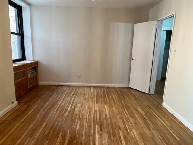 200 Corbin Place, Unit 2H Brooklyn, NY 11235 - Photo 3 of 18 a view of an empty room with wooden floor and a window