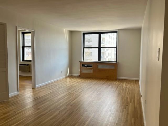 200 Corbin Place, Unit 2H Brooklyn, NY 11235 - Photo 6 of 18 an empty room with wooden floor and windows