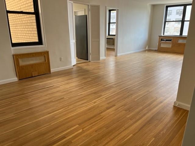 200 Corbin Place, Unit 2H Brooklyn, NY 11235 - Photo 7 of 18 an empty room with wooden floor and windows