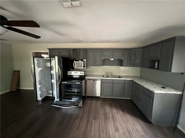 a kitchen with sink cabinets and wooden floor