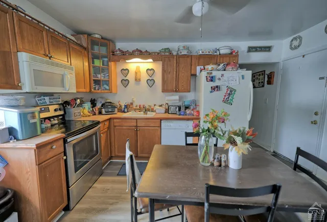 a kitchen with stainless steel appliances a stove a sink cabinets and a dining table