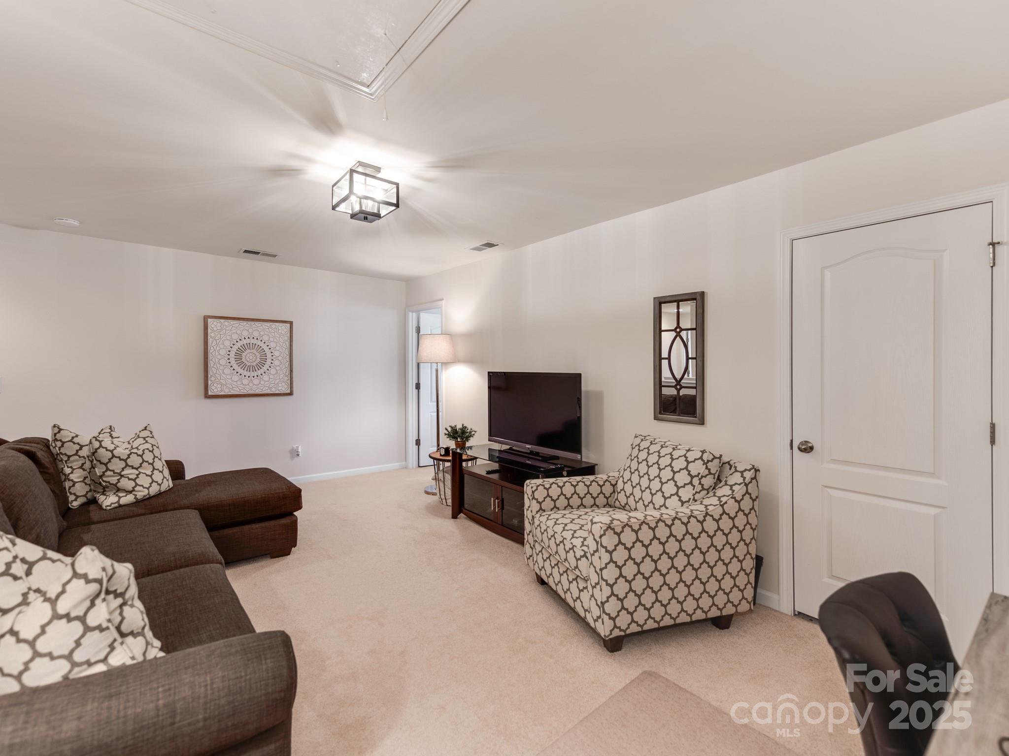 8244 Viewpoint Lane Cornelius, NC 28031 - Photo 20 of 33 a living room with furniture and a flat screen tv