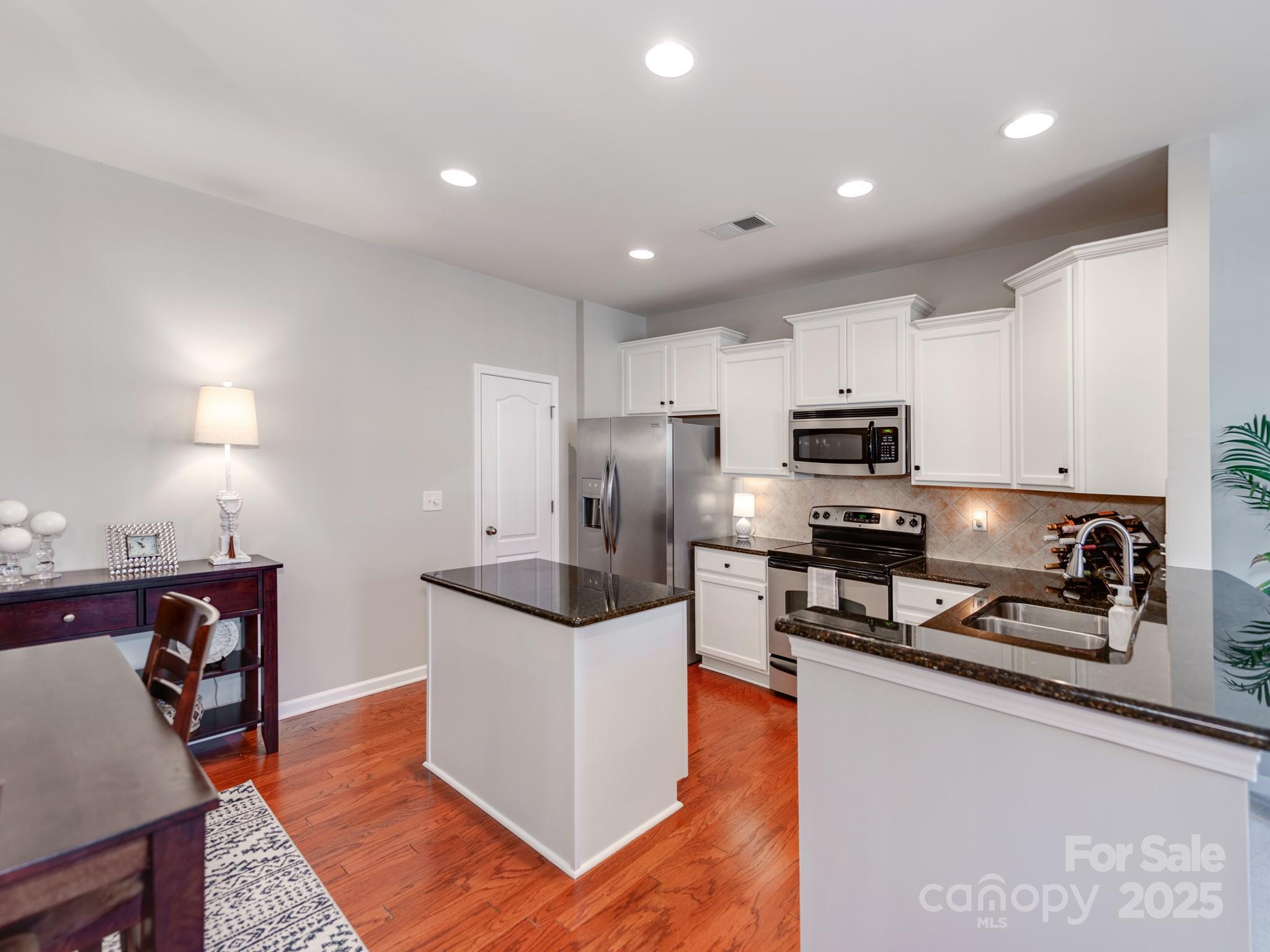 8244 Viewpoint Lane Cornelius, NC 28031 - Photo 10 of 33 a kitchen with stainless steel appliances a microwave a stove a sink a refrigerator and cabinets