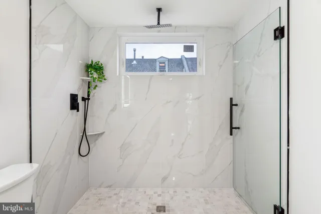a bathroom with a granite countertop shower and a sink