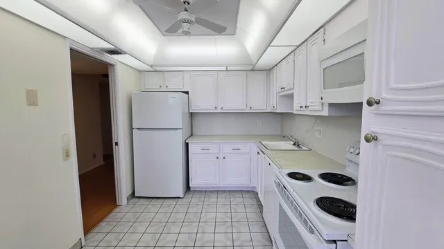 a kitchen with a refrigerator sink and cabinets