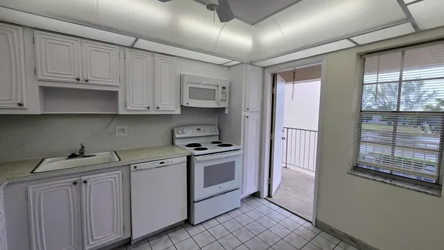 a kitchen with white cabinets and appliances