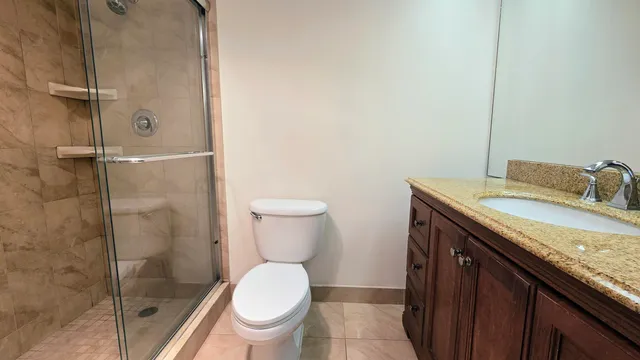 a bathroom with a granite countertop sink toilet and shower