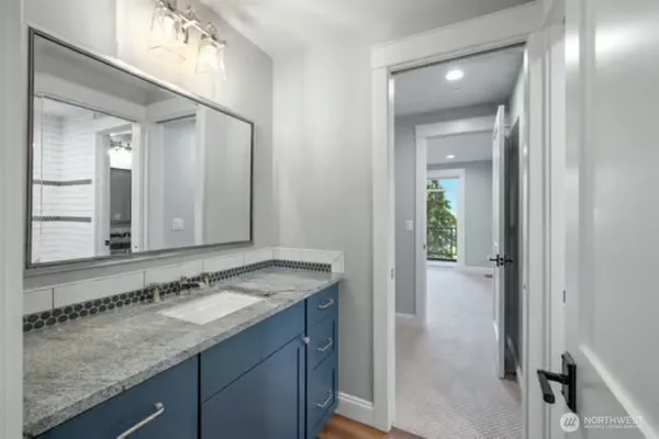 a bathroom with a granite countertop sink and a mirror