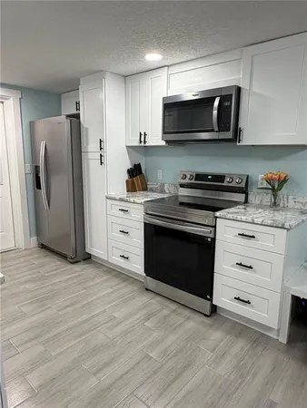 a kitchen with stainless steel appliances a stove microwave and refrigerator
