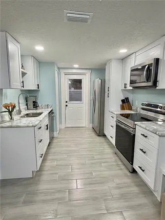 a kitchen with white cabinets and stainless steel appliances
