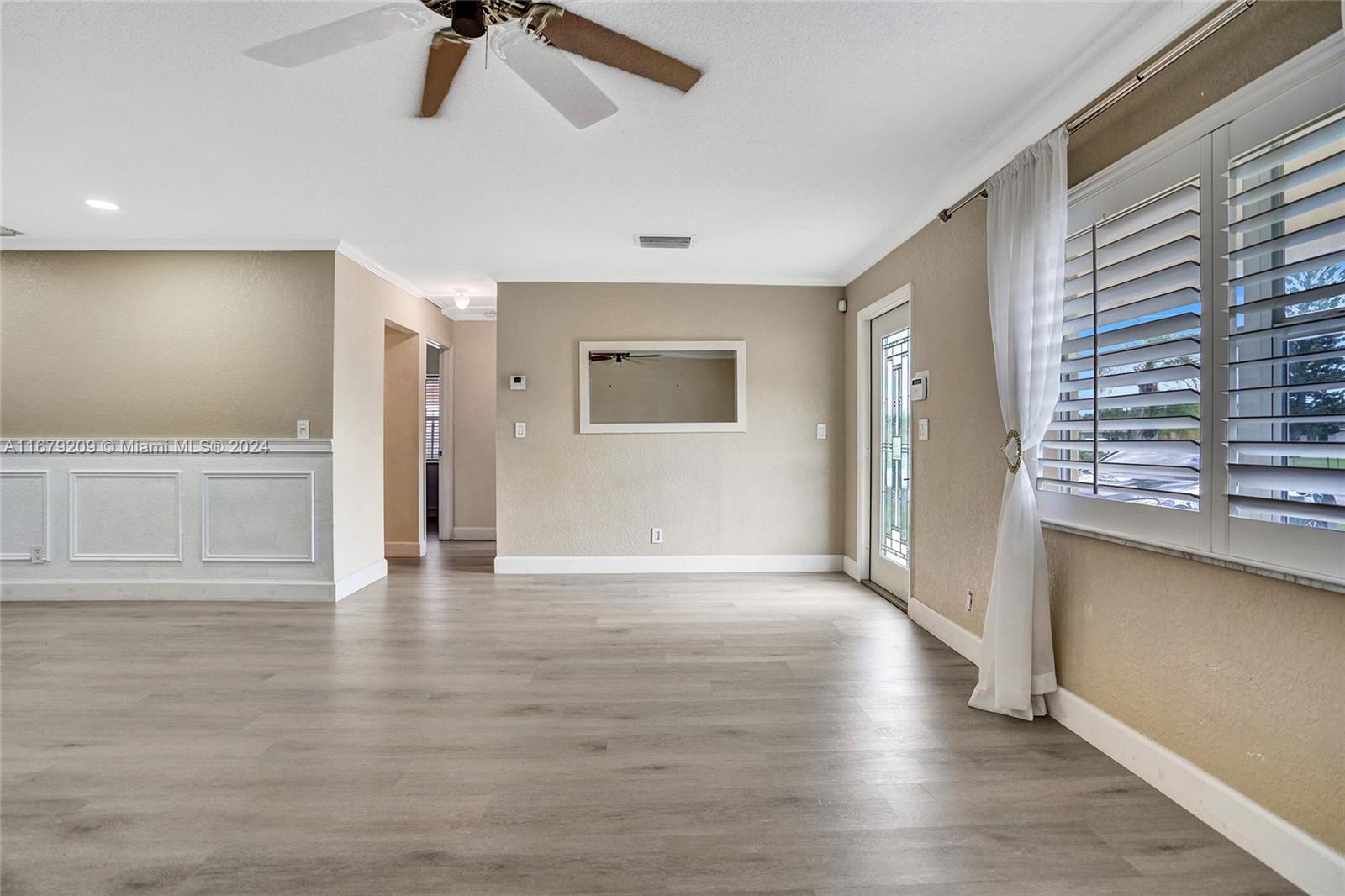 9737 Alaska Circle Boca Raton, FL 33434 - Photo 12 of 37 a view of an empty room with a window and wooden floor