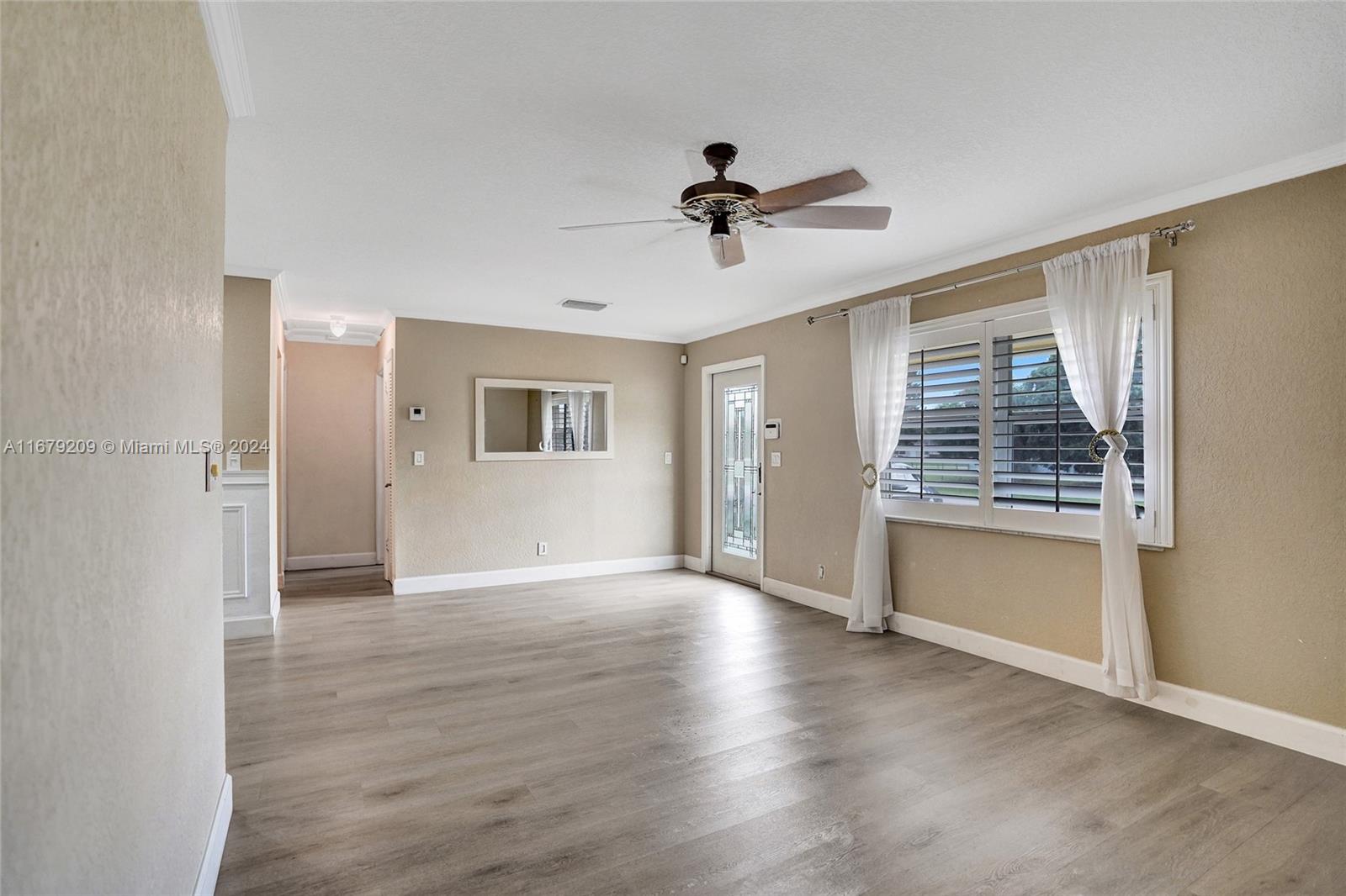 9737 Alaska Circle Boca Raton, FL 33434 - Photo 13 of 37 a view of an empty room with a window and wooden floor