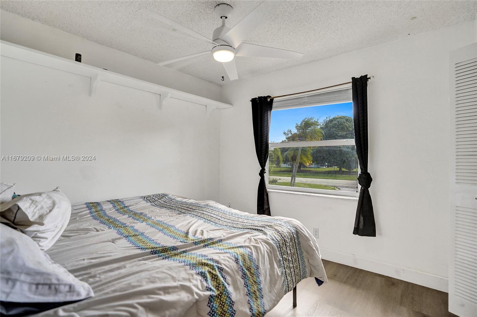 9737 Alaska Circle Boca Raton, FL 33434 - Photo 16 of 37 a bedroom with a bed and a large window