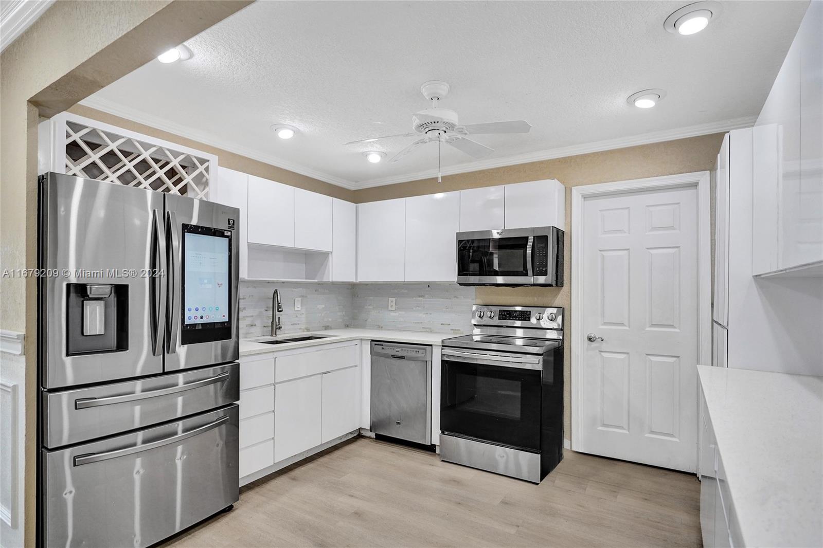 9737 Alaska Circle Boca Raton, FL 33434 - Photo 18 of 37 a kitchen with stainless steel appliances granite countertop a refrigerator and a stove top oven