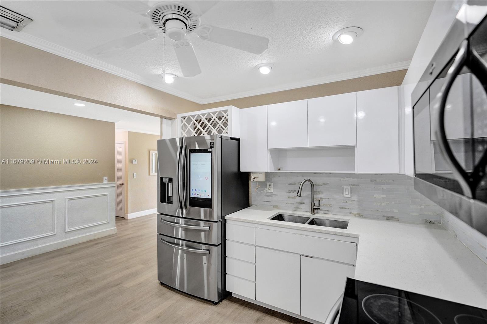 9737 Alaska Circle Boca Raton, FL 33434 - Photo 20 of 37 a kitchen with stainless steel appliances a refrigerator sink and cabinets