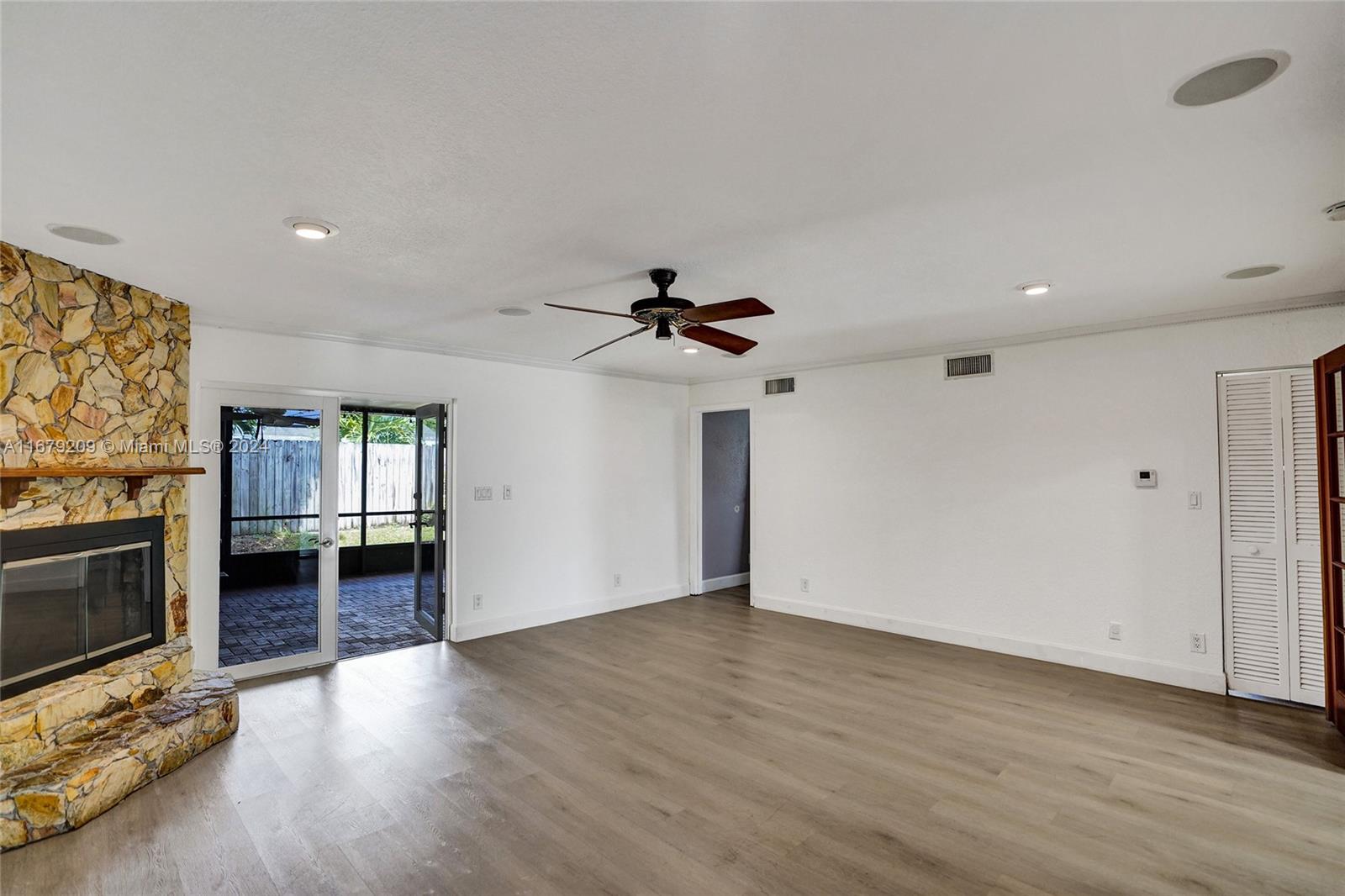9737 Alaska Circle Boca Raton, FL 33434 - Photo 22 of 37 an empty room with wooden floor fireplace and windows