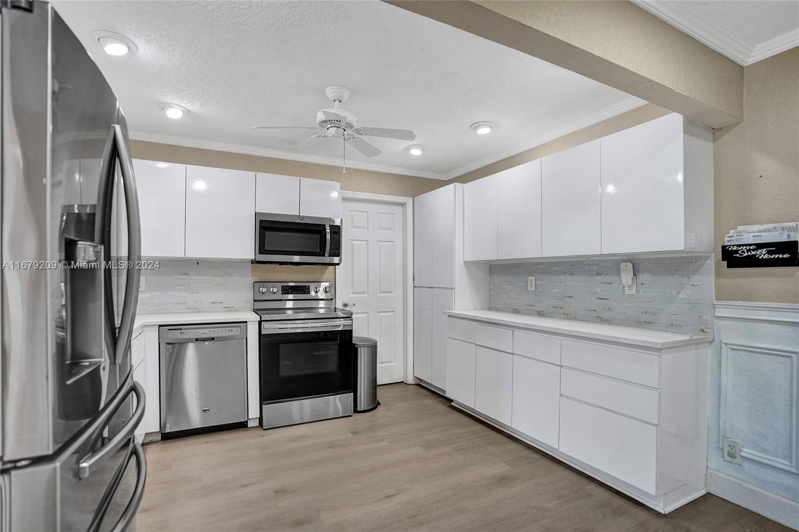 9737 Alaska Circle Boca Raton, FL 33434 - Photo 3 of 37 a kitchen with stainless steel appliances granite countertop a stove and a refrigerator