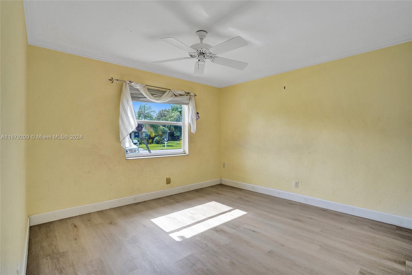 9737 Alaska Circle Boca Raton, FL 33434 - Photo 5 of 37 an empty room with a ceiling fan and window