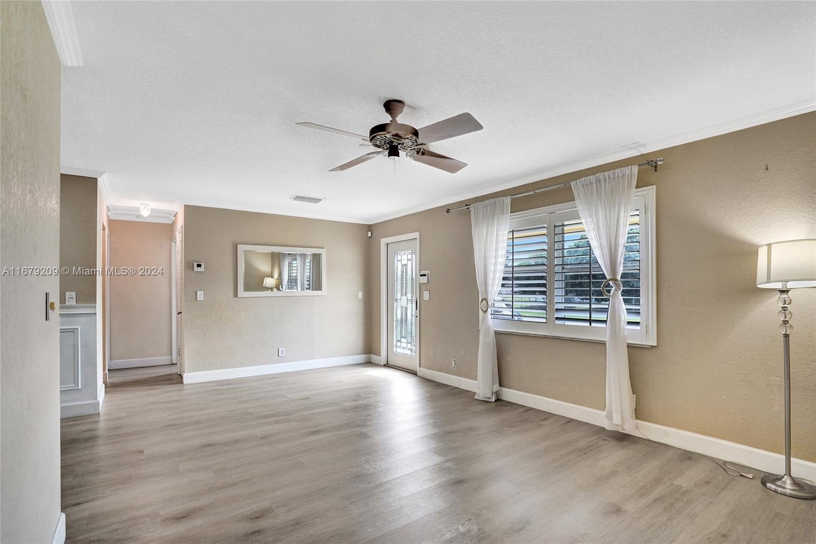 9737 Alaska Circle Boca Raton, FL 33434 - Photo 9 of 37 an empty room with wooden floor a ceiling fan and windows