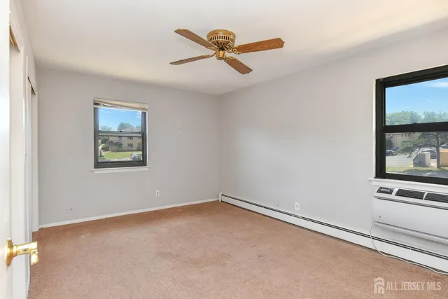 an empty room with windows and ceiling fan