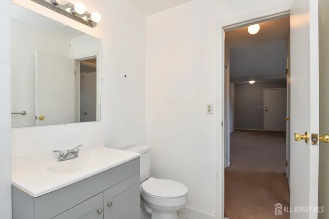 a bathroom with a sink vanity mirror and toilet