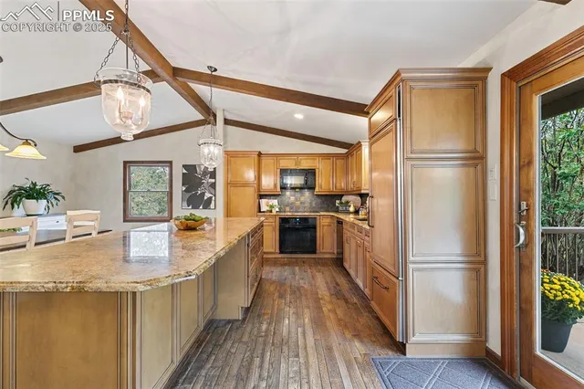 a kitchen with stainless steel appliances granite countertop a refrigerator a oven a sink and dishwasher with wooden floor