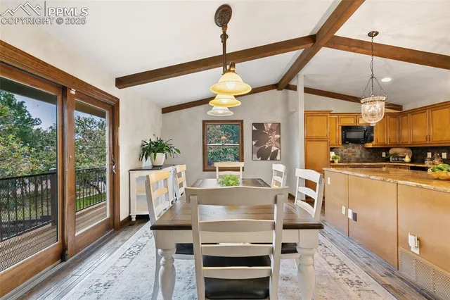 a dining room with wooden floor a chandelier a wooden table and chairs