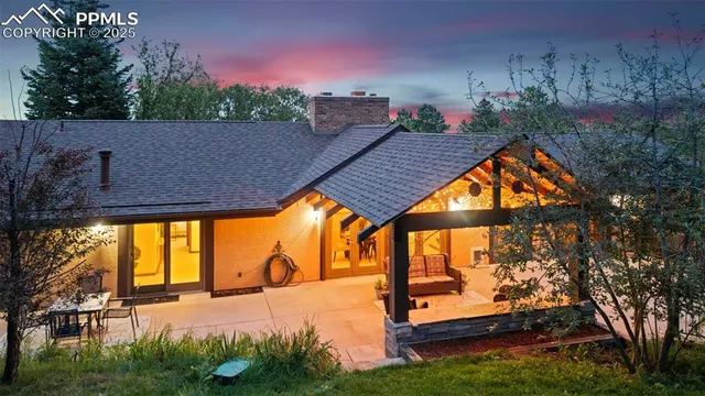 a view of a house with backyard and sitting area