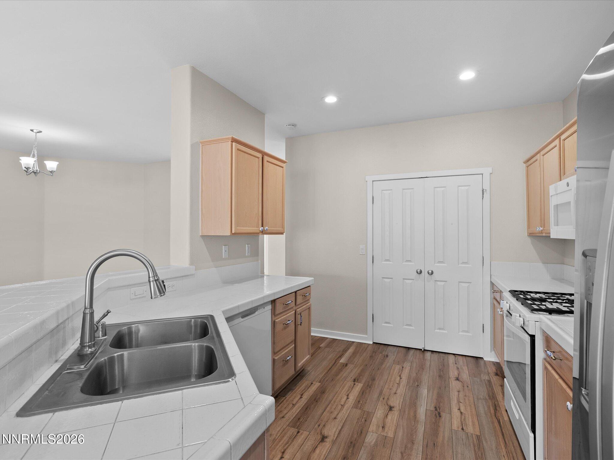5570 Knoll View Way Sparks, NV 89436 - Photo 25 of 69 a kitchen with a sink and a stove top oven with wooden floor