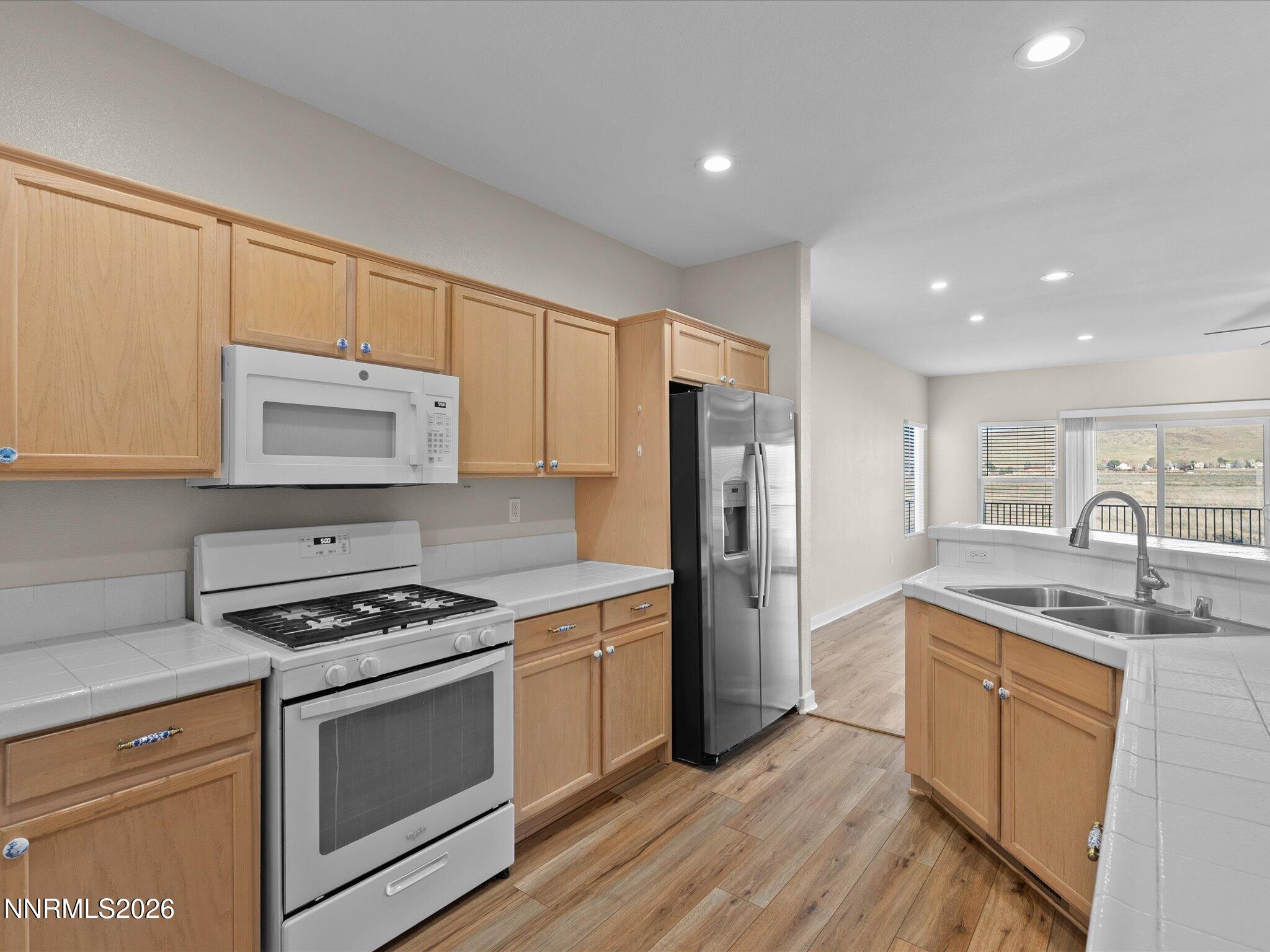 5570 Knoll View Way Sparks, NV 89436 - Photo 27 of 69 a kitchen with granite countertop a sink stove and refrigerator