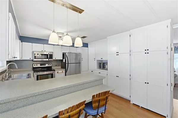 a kitchen with stainless steel appliances a stove a refrigerator and cabinets