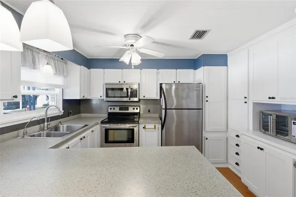 a view of a kitchen with white cabinets
