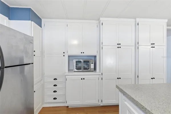 a kitchen with stainless steel appliances granite countertop a sink a stove and a white cabinets
