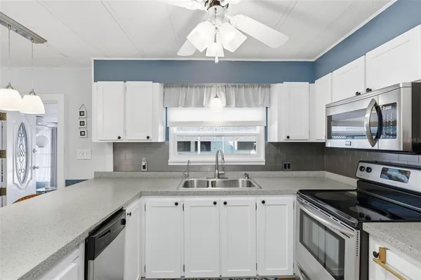 a kitchen with stainless steel appliances granite countertop a dining table chairs a sink and dishwasher a refrigerator with wooden floor